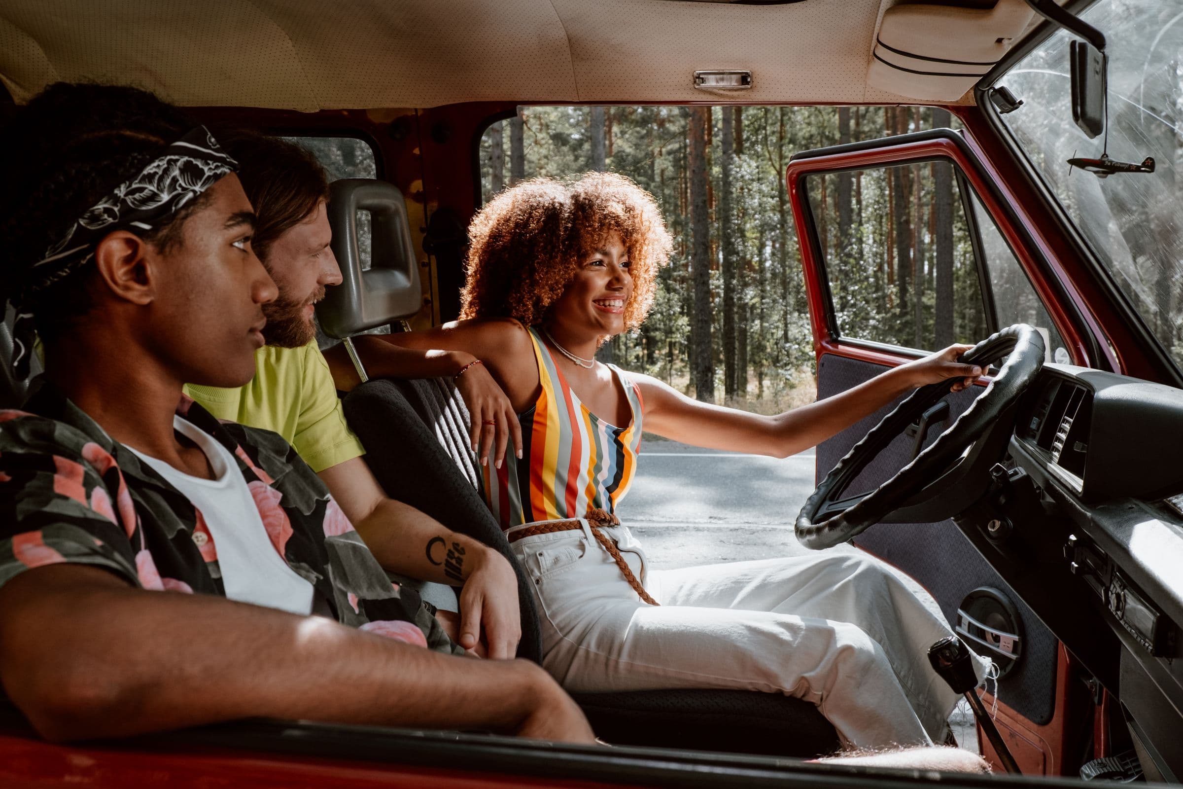 A group of young friends setting out together in a vintage vehicle on a summer road