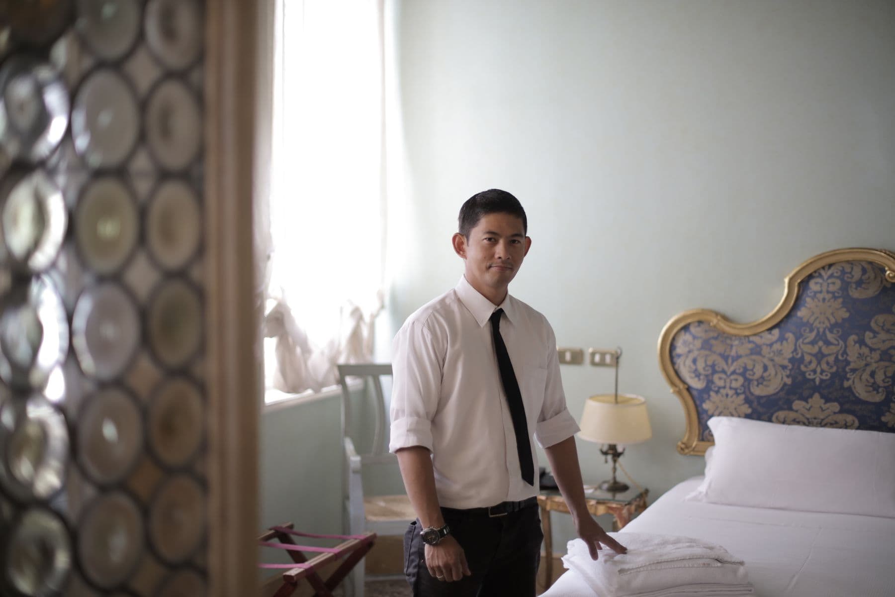 A hotel team member preparing a guest room