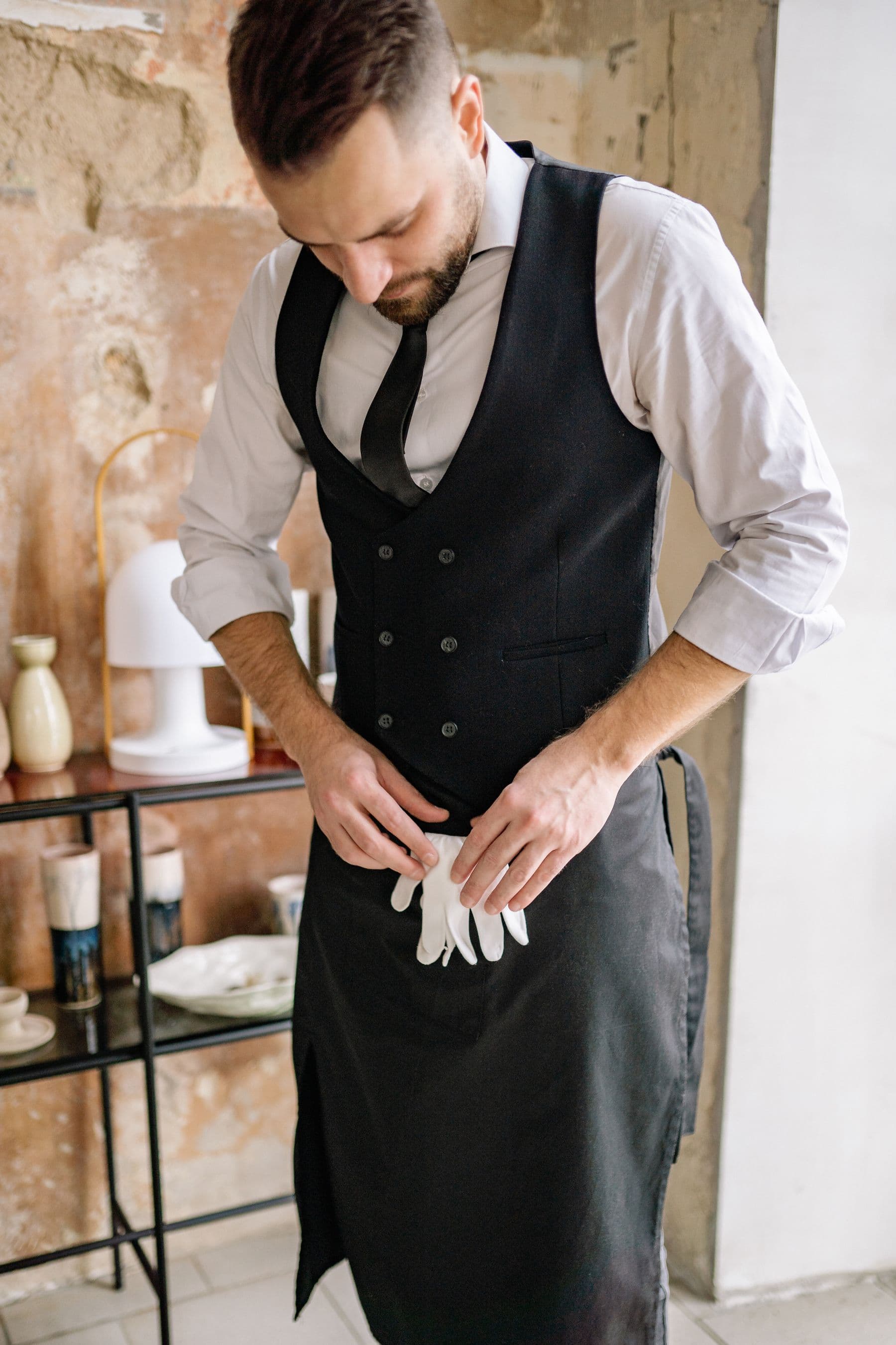 A young hospitality worker preparing for a restaurant shift